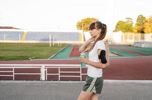 Teenager-Mädchen, das nach dem Training mit der Papiertüte im Stadion spazieren geht foto