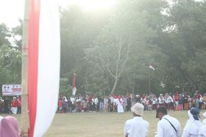 Gorontalo, Indonesien - - August 17, 2023 - - das indonesisch Flagge Senkung Zeremonie bezeugt durch Dorfbewohner. Indonesien Unabhängigkeit Tag foto