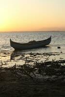 Boot im das See beim Sonnenuntergang. Rudern Boot schwebend Über das Schwebe See Gewässer. Gorontalo, Indonesien foto