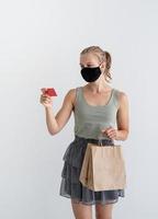 Frau in Schutzmaske mit umweltfreundlichen Einkaufstüten foto