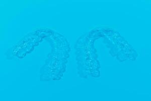 unsichtbar Dental Zähne Klammern Zahn Aligner auf Blau Hintergrund. Plastik Hosenträger Zahnheilkunde Halter zu begradigen Zähne. foto