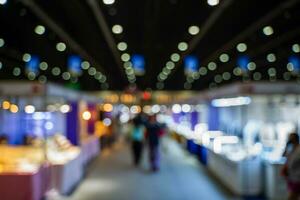 verschwommen Bilder von Handel Messen im das groß Halle. Bild von Menschen Gehen auf ein Handel Messe Ausstellung oder Messe wo Geschäft Menschen Show Innovation Aktivität und Geschenk Produkte im ein groß Halle. foto