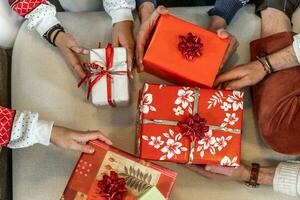 Gruppe von jung freunde Austausch Weihnachten Geschenke auf das Sofa foto