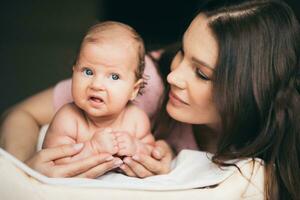 Porträt von ein jung Frau Wer zärtlich kümmert sich zum ihr Baby foto