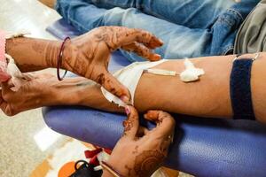 blutspender im blutspendecamp mit einem hüpfball in der hand gehalten im balaji-tempel, vivek vihar, delhi, indien, bild für den weltblutspendetag am 14. juni jedes jahr, blutspendecamp foto