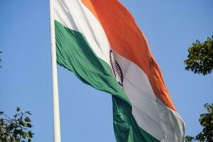 Indien-Flagge, die hoch am Connaught-Platz mit Stolz auf den blauen Himmel fliegt, Indien-Flagge flattert, indische Flagge am Unabhängigkeitstag und Tag der Republik Indien, Schuss nach oben geneigt, indische Flagge schwenkend, Har Ghar Tiranga foto