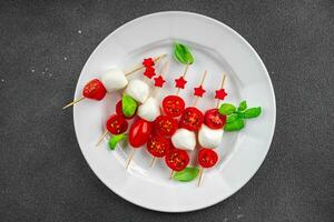 Caprese Häppchen Mozzarella und Tomate Vorspeise Salat auf ein Spieß Finger Essen köstlich gesund Essen Kochen Vorspeise Mahlzeit Essen Snack auf das Tabelle Kopieren Raum Essen Hintergrund rustikal oben Aussicht foto