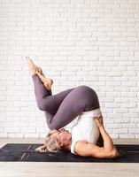 junge attraktive Frau, die Yoga praktiziert, Sportkleidung trägt foto