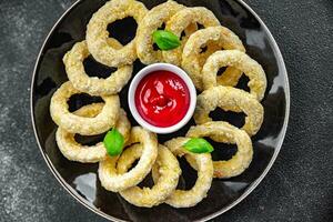 Zwiebel Ringe im Teig tief Friteuse Tomate Soße schnell Essen köstlich Essen Kochen Vorspeise Mahlzeit Essen Snack auf das Tabelle Kopieren Raum foto