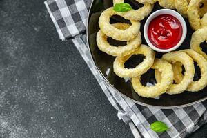 Zwiebel Ringe im Teig tief Friteuse Tomate Soße schnell Essen köstlich Essen Kochen Vorspeise Mahlzeit Essen Snack auf das Tabelle Kopieren Raum foto