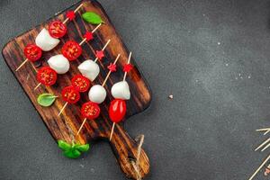 Caprese Häppchen Mozzarella und Tomate Vorspeise Salat auf ein Spieß Finger Essen köstlich gesund Essen Kochen Vorspeise Mahlzeit Essen Snack auf das Tabelle Kopieren Raum Essen Hintergrund foto