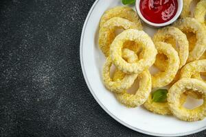 Zwiebel Ringe im Teig tief Friteuse Tomate Soße schnell Essen köstlich Essen Kochen Vorspeise Mahlzeit Essen Snack auf das Tabelle Kopieren Raum foto