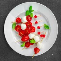 Tomate und Mozzarella Salat auf ein Spieß Caprese Finger Essen Vorspeise Essen Kochen Vorspeise Mahlzeit Essen Snack auf das Tabelle foto