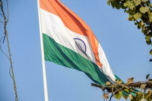 Indien-Flagge, die hoch am Connaught-Platz mit Stolz auf den blauen Himmel fliegt, Indien-Flagge flattert, indische Flagge am Unabhängigkeitstag und Tag der Republik Indien, Schuss nach oben geneigt, indische Flagge schwenkend, Har Ghar Tiranga foto