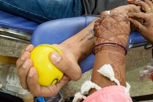 blutspender im blutspendecamp mit einem hüpfball in der hand gehalten im balaji-tempel, vivek vihar, delhi, indien, bild für den weltblutspendetag am 14. juni jedes jahr, blutspendecamp foto