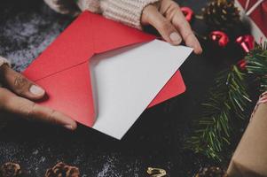 Hände halten geöffnete Weihnachtskarte oder Brief foto