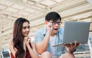 asiatische Paare, die mit Laptop suchen, um zu suchen