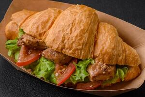 köstlich frisch knusprig Croissant mit Hähnchen oder Rindfleisch Fleisch, Kopfsalat, Tomaten, Gewürze und Soße foto