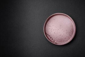 leeren runden Keramik Teller auf ein dunkel texturiert Hintergrund foto