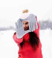 Frau im roten Pullover, die mit ihren Händen Rahmenzeichen macht foto