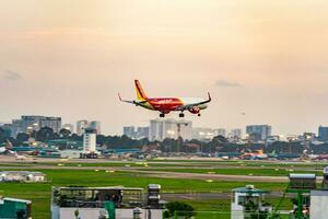 ho Chi Minh, Vietnam - - 7 August 2023 Fluggesellschaften fliegen Vergangenheit Wahrzeichen 81, das höchste Gebäude im Vietnam, zu Land beim bräunen Sohn Nhat International Flughafen. foto