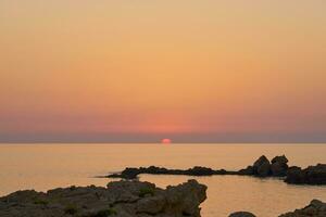das Stein Küste von das Mittelmeer Meer beim Sonnenuntergang. foto