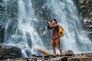 Mann, der ein Foto von einem Wasserfall macht