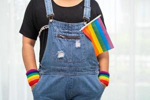 asiatische Dame mit Regenbogenflagge, LGBT-Symbol foto