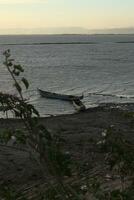 Boot im das See beim Sonnenuntergang. Rudern Boot schwebend Über das Schwebe See Gewässer. Gorontalo, Indonesien foto