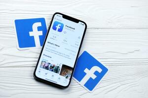 charkow, ukraine - 5. märz 2021 facebook-symbol und anwendung aus dem app store auf dem iphone 12 pro bildschirm auf einem weißen tisch foto