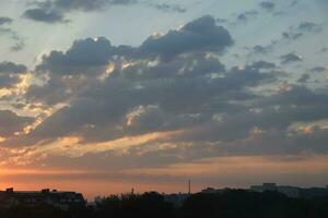 schön Sonnenaufgang mit warm Orange Sonnenlicht und Balken durch Blau Himmel foto