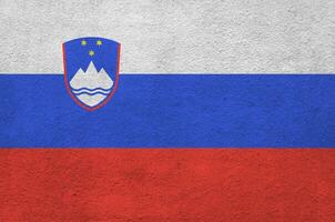 slowenische flagge in hellen farben auf alter reliefputzwand dargestellt. strukturierte Fahne auf rauem Hintergrund foto