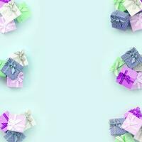 Stapel von kleinen farbigen Geschenkboxen mit Bändern liegen auf violettem Hintergrund. Minimalismus flaches Draufsichtmuster foto