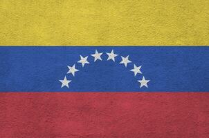 venezuela-flagge in hellen farben auf alter reliefputzwand dargestellt. strukturierte Fahne auf rauem Hintergrund foto