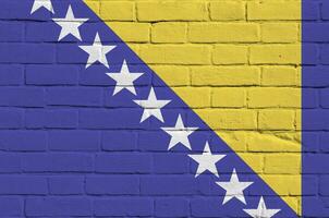 Bosnien und Herzegowina Flagge abgebildet im Farbe Farben auf alt Backstein Mauer. texturiert Banner auf groß Backstein Mauer Mauerwerk Hintergrund foto