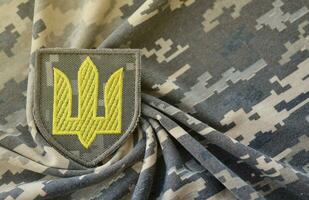 Symbol von ukrainisch Heer auf das tarnen Uniform von ein ukrainisch Soldat. das Konzept von Krieg im Ukraine, Patriotismus und schützen Ihre Land von Besatzer foto