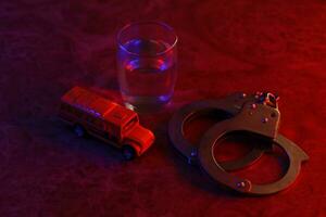 Glas mit Wodka Alkohol trinken, Messer und Handschellen. Konzept von Alkoholismus, kriminell foto