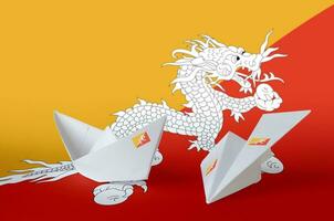 Bhutan Flagge abgebildet auf Papier Origami Flugzeug und Boot. handgemacht Kunst Konzept foto