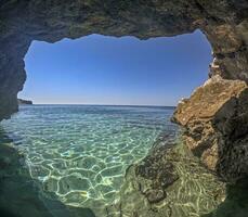 Bild genommen von ein Grotte gegenüber das öffnen Meer mit Türkis Wasser foto