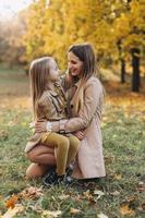 Mutter und Tochter haben Spaß und gehen im Herbstpark spazieren. foto