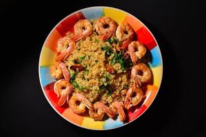 Risotto mit Muscheln und Garnelen auf einem bunten schönen Teller foto