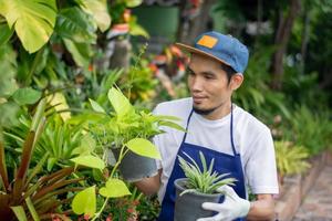 asiatischer Mann verkauft gerne Pflanzengarten im Shop foto