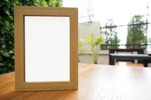 Mock-up leeren weißen Rahmen auf Holztisch stehend foto
