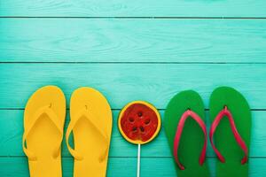 Flip Flops und Süßigkeiten auf Blau hölzern Hintergrund. oben Sicht. Sommer- Urlaub. spotten hoch. Kopieren Raum foto