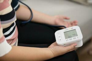 Frau Übergewicht Plus Größe selbst prüft Messung Blut Druck und Herz Bewertung Tonometer selbst Untersuchung beim Zuhause foto