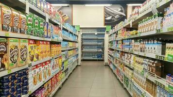 Perspektive Aussicht von Kunde Einkaufen Verbraucher gut auf Regale zwischen Gang mit klar Licht im Bequemlichkeit Supermarkt und minimart foto