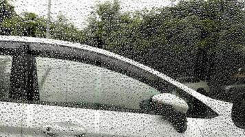 Regentropfen auf Fenster mit Autohintergrund. foto
