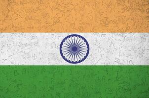 indische flagge in hellen farben auf alter reliefputzwand dargestellt. strukturierte Fahne auf rauem Hintergrund foto