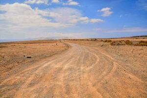 ein Schmutz Straße im das Mitte von ein Wüste foto