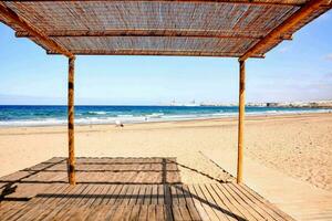 ein hölzern Struktur auf das Strand mit ein Blau Himmel foto